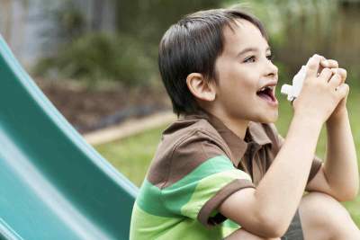 Image showing child on a slide with an inhaler in park